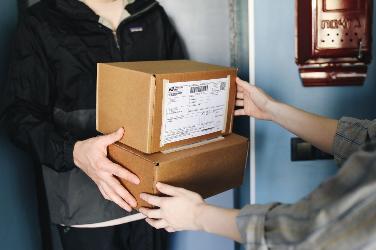 The Art of Drawing Readers In: Your attractive post title goes here Close-up of hands exchanging cardboard boxes indoors, symbolizing delivery service.